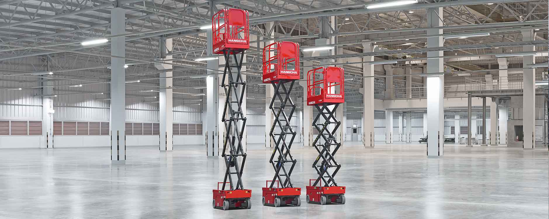 three self propelled electric scissor lift in the empty warehouse
