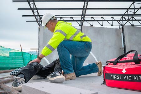 safety worker providing first aid to someone who has fallen from a height