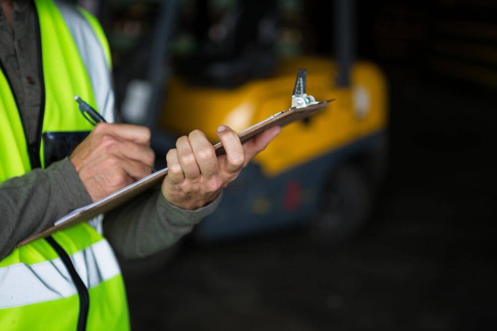 Safety Officer is reviewing the checklist for routine forklift maintenance